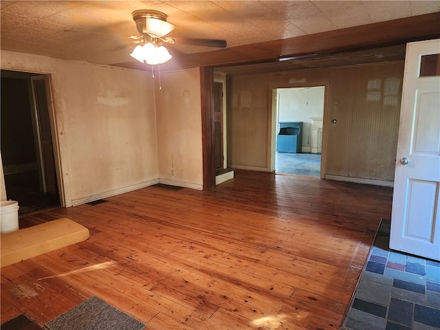 spare room featuring hardwood / wood-style floors, ceiling fan, and washer / dryer