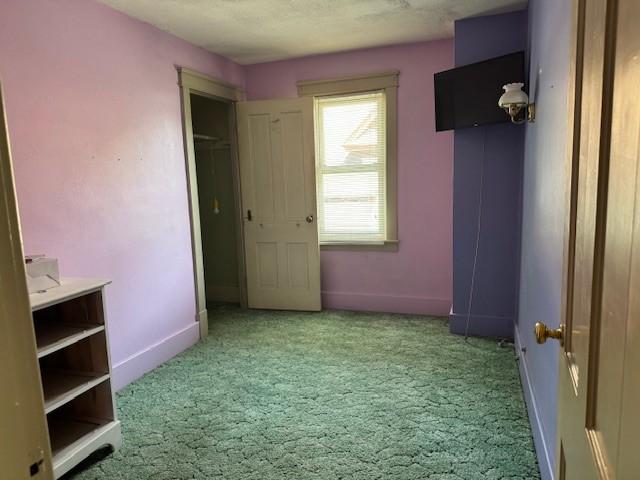 unfurnished bedroom featuring carpet and baseboards