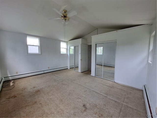 unfurnished bedroom featuring ceiling fan, light colored carpet, baseboard heating, and vaulted ceiling