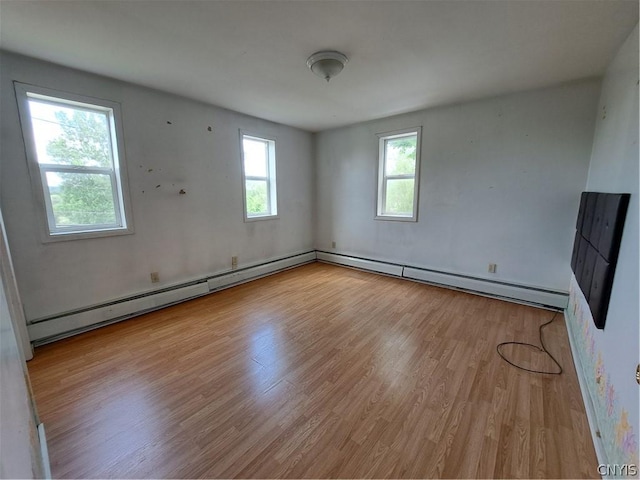 spare room with a baseboard radiator and light hardwood / wood-style flooring