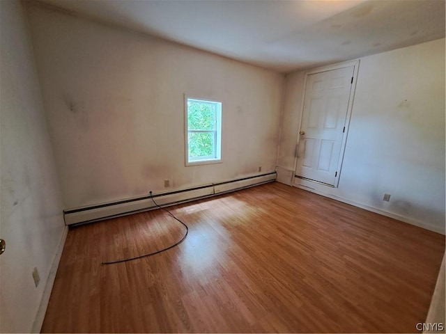 spare room featuring hardwood / wood-style floors and a baseboard radiator