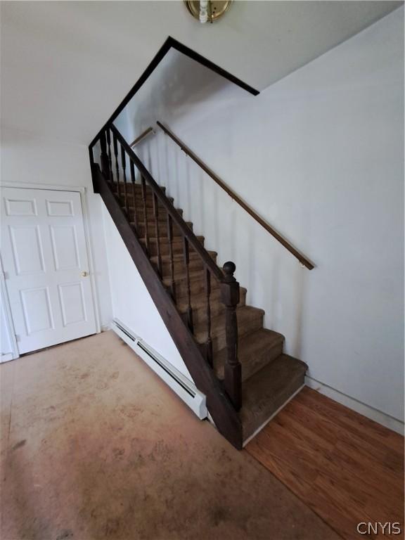 stairway featuring baseboard heating and hardwood / wood-style flooring