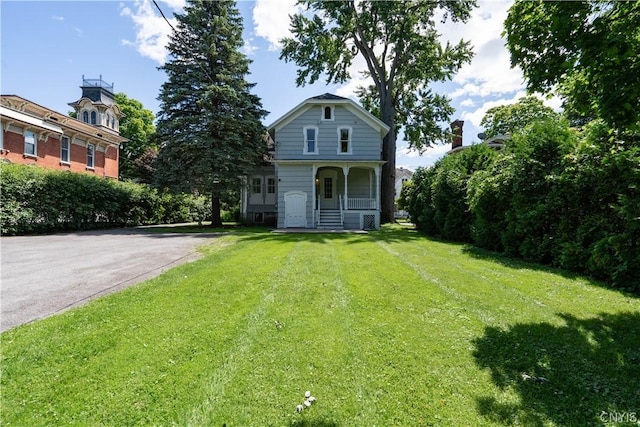 view of front of property featuring covered porch and a front yard