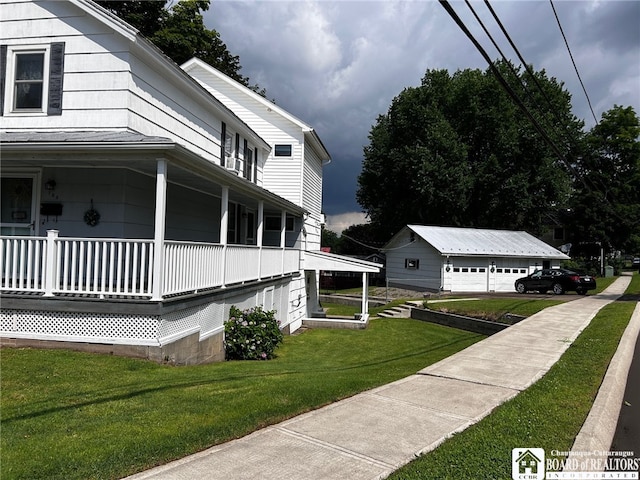 view of side of property with a garage, a yard, an outdoor structure, and a porch