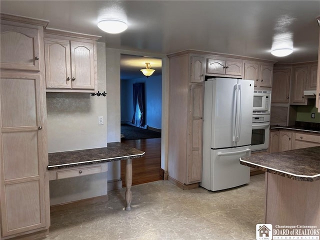 kitchen with white appliances, kitchen peninsula, and light brown cabinets