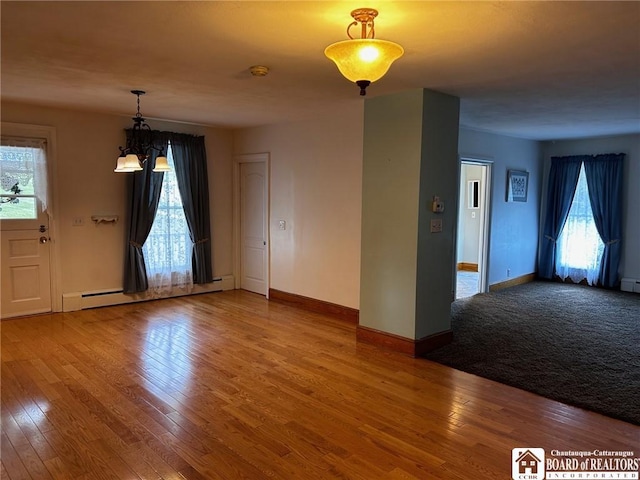 interior space featuring an inviting chandelier, hardwood / wood-style flooring, plenty of natural light, and baseboard heating