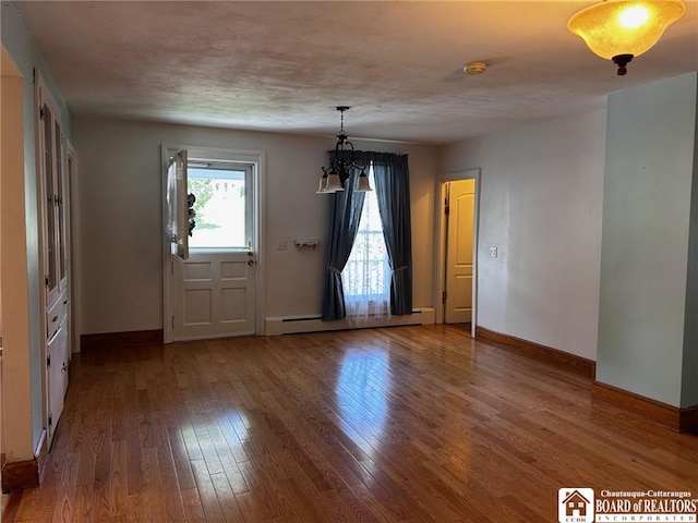 interior space featuring baseboard heating and hardwood / wood-style floors