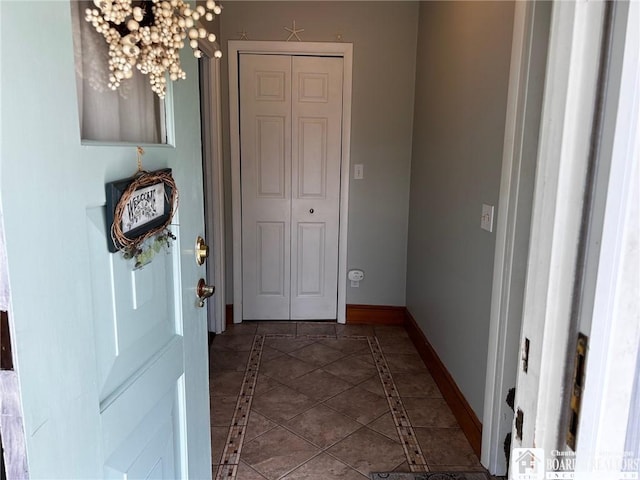 hallway with dark tile patterned flooring