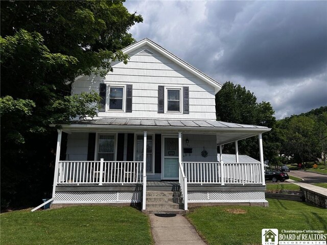 farmhouse featuring a front lawn and a porch