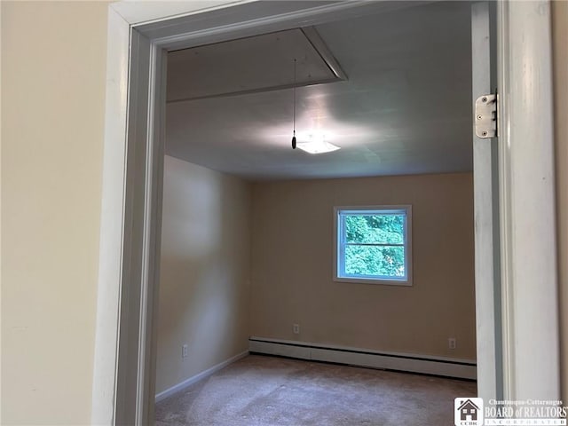 spare room with carpet floors and a baseboard heating unit