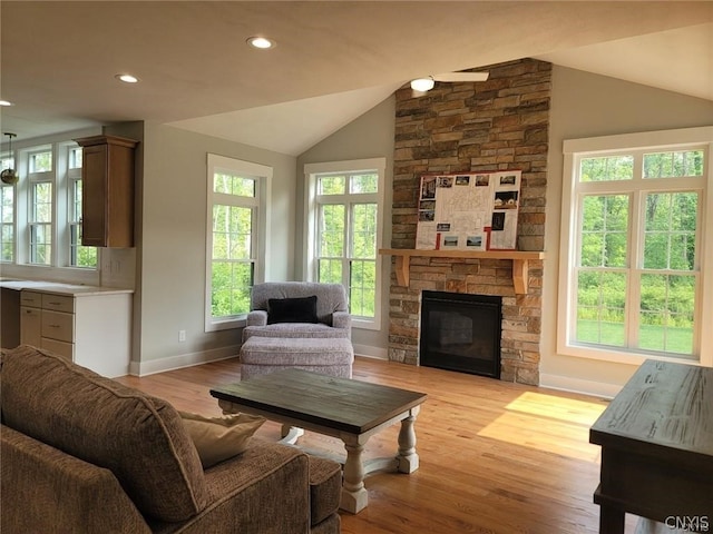 living room featuring light hardwood / wood-style floors, vaulted ceiling, and a fireplace