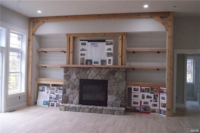 unfurnished living room featuring a stone fireplace and hardwood / wood-style flooring