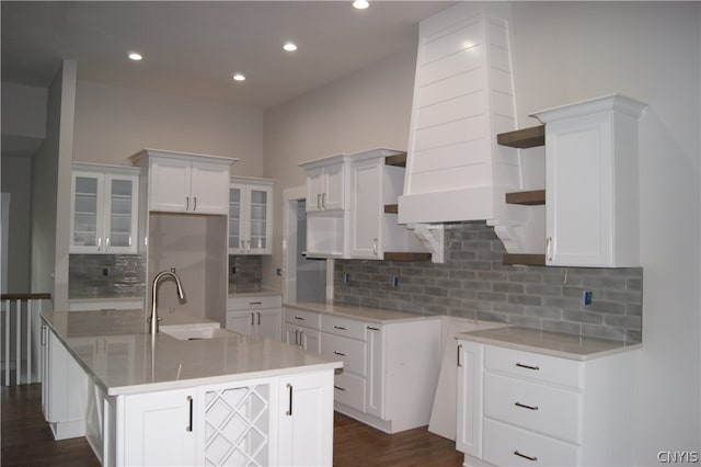 kitchen with sink, white cabinets, and a center island with sink