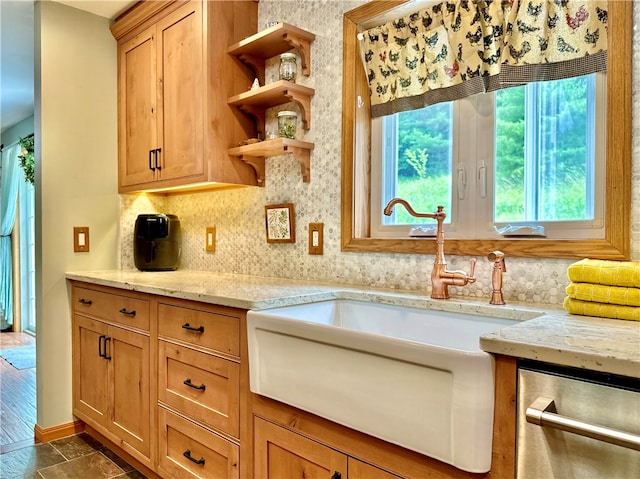 kitchen featuring dark hardwood / wood-style floors, stainless steel dishwasher, sink, and light stone counters