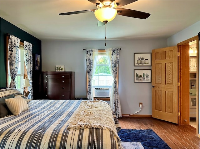 bedroom featuring ceiling fan, cooling unit, light wood-type flooring, and ensuite bath