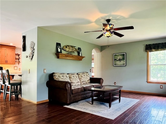 living room with ceiling fan and dark wood-type flooring