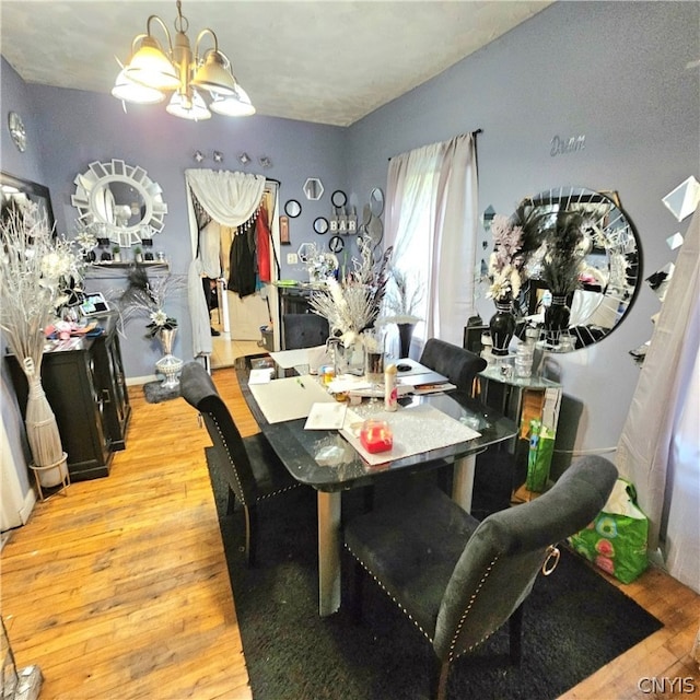 dining space with a notable chandelier and light hardwood / wood-style flooring