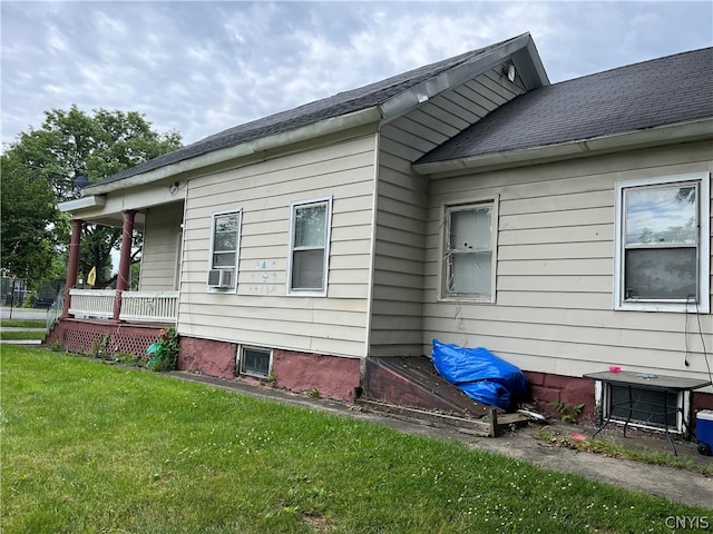 view of side of home with cooling unit and a yard