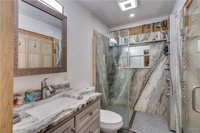 bathroom featuring vanity, toilet, and a shower with shower door