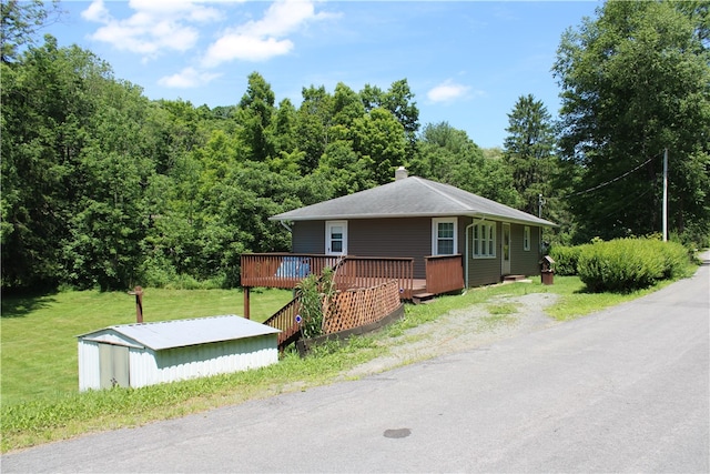 view of front facade featuring a wooden deck and a front yard