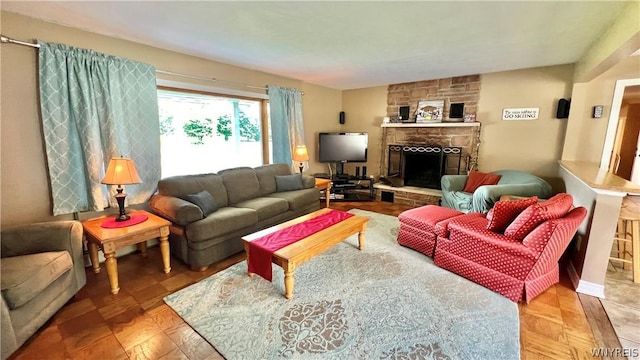 living room featuring a stone fireplace