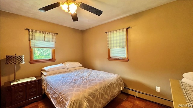 bedroom featuring baseboard heating, ceiling fan, and dark parquet floors