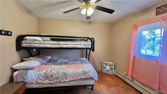 bedroom with ceiling fan, parquet flooring, and a baseboard heating unit