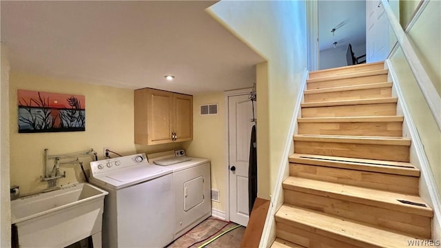 laundry area with washer and clothes dryer, cabinets, and sink