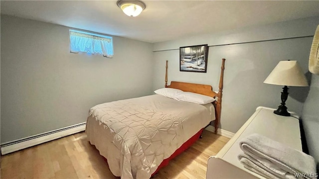 bedroom featuring wood-type flooring and baseboard heating