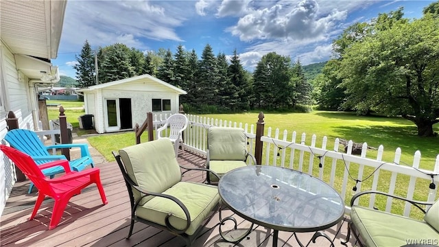 wooden deck with a lawn and an outdoor structure