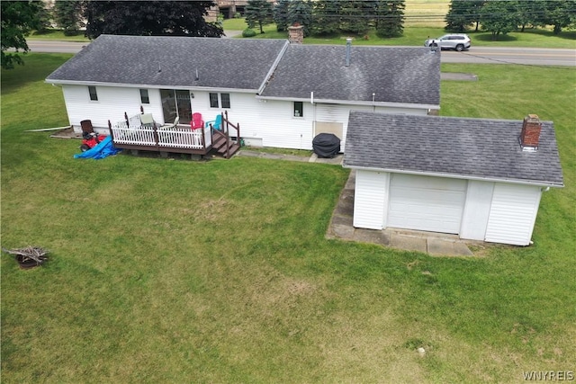 rear view of property with a yard, a wooden deck, an outbuilding, and a garage