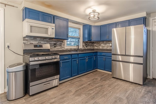 kitchen featuring backsplash, sink, blue cabinets, appliances with stainless steel finishes, and light hardwood / wood-style floors