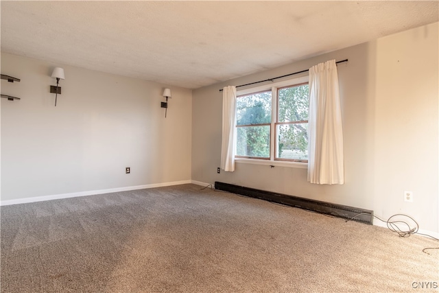 carpeted empty room with a textured ceiling and a baseboard radiator