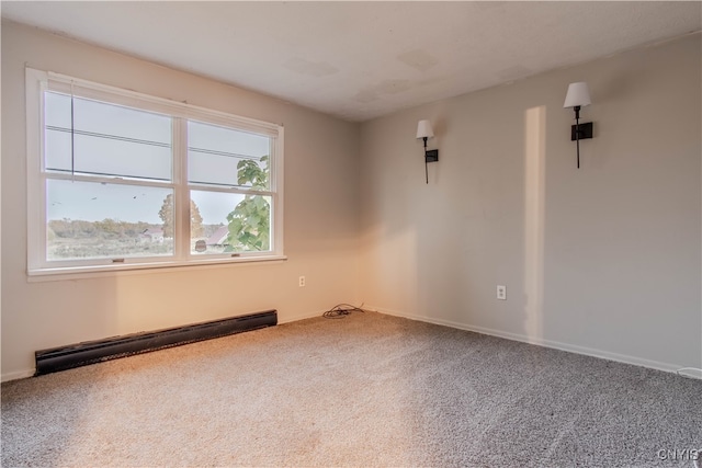 carpeted empty room with a wealth of natural light and baseboard heating