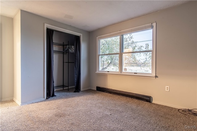 unfurnished bedroom featuring a closet, carpet floors, and a baseboard heating unit