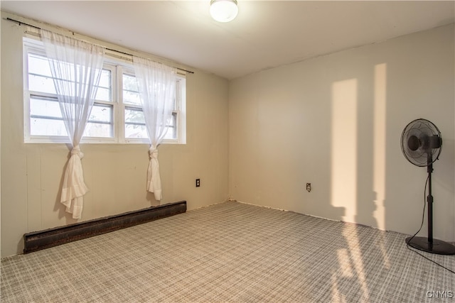 empty room featuring a baseboard radiator and carpet