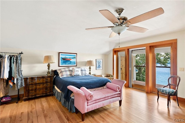 bedroom with access to exterior, light hardwood / wood-style flooring, ceiling fan, and vaulted ceiling