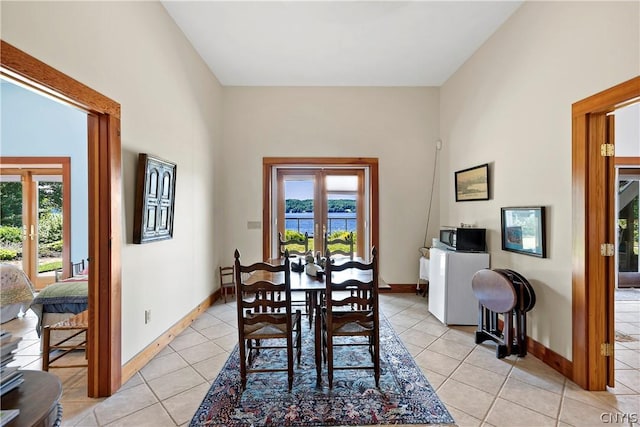 dining space featuring a wealth of natural light, light tile patterned floors, and french doors