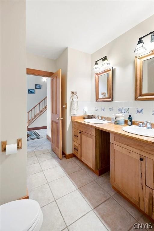 bathroom featuring tile patterned flooring, vanity, tasteful backsplash, and toilet