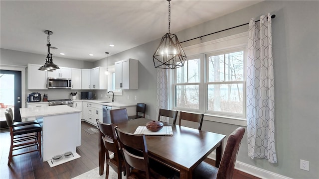 dining space featuring dark hardwood / wood-style floors, a notable chandelier, and sink