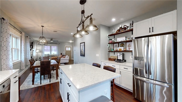 kitchen with a center island, hanging light fixtures, ceiling fan, appliances with stainless steel finishes, and white cabinetry