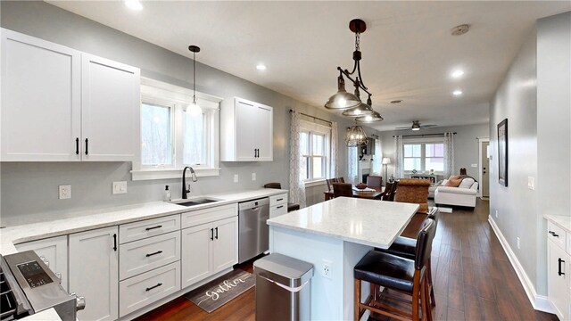 kitchen with white cabinets, stainless steel dishwasher, hanging light fixtures, and ceiling fan