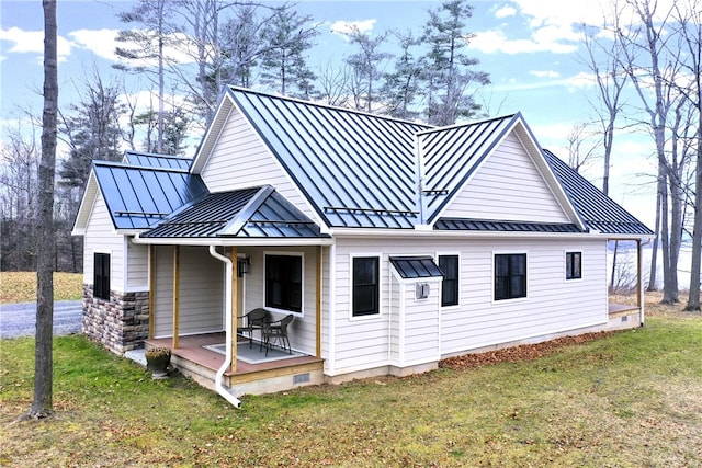 back of property with a lawn and covered porch