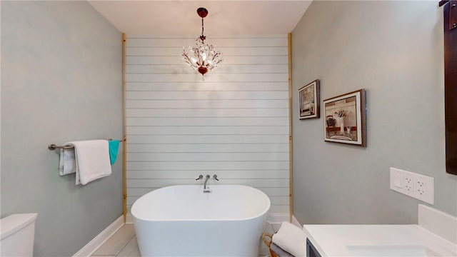 bathroom with vanity, a bath, tile patterned floors, toilet, and a chandelier