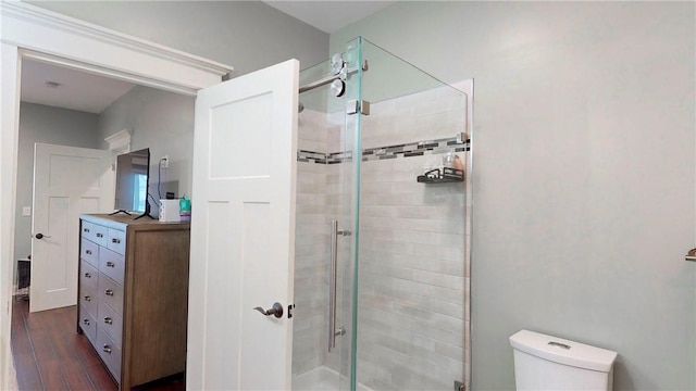 bathroom with toilet, wood-type flooring, and walk in shower