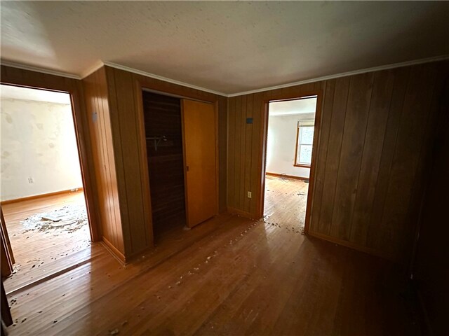 unfurnished bedroom featuring ornamental molding, a closet, and hardwood / wood-style floors