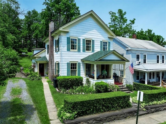 view of front of property with covered porch and a front yard