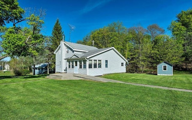 view of side of home with a shed and a yard