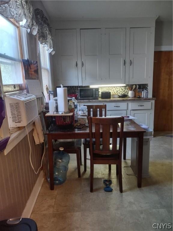 kitchen with white cabinetry, decorative backsplash, and cooling unit