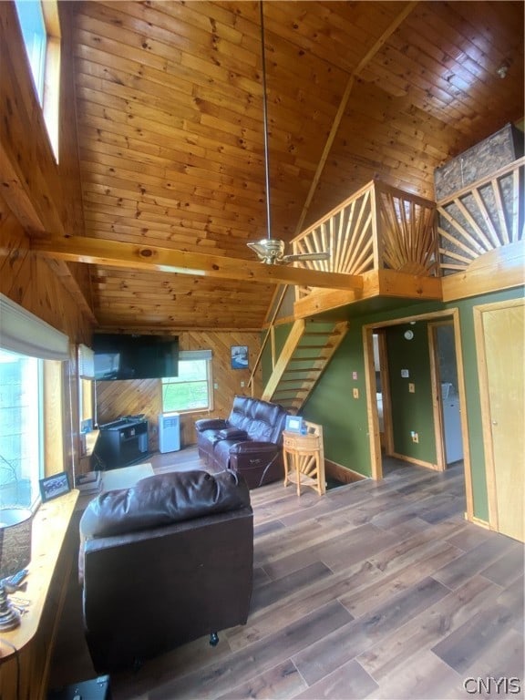 living room with high vaulted ceiling, wooden ceiling, hardwood / wood-style flooring, and wooden walls